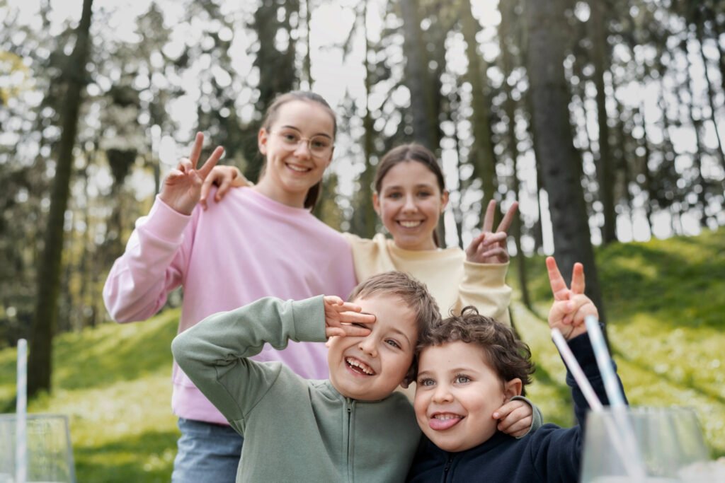 Two mothers and their children smiling together in a park