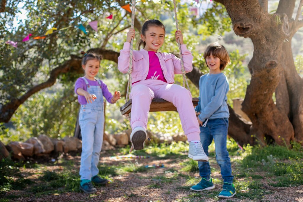 Children playing on a tree swing in a park